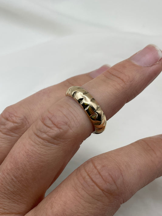 Gold ring on a finger against a white background