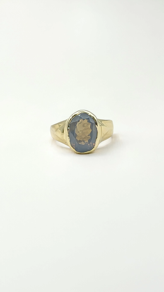 A gold signet ring with a lavender moon quartz stone against a plain white background.